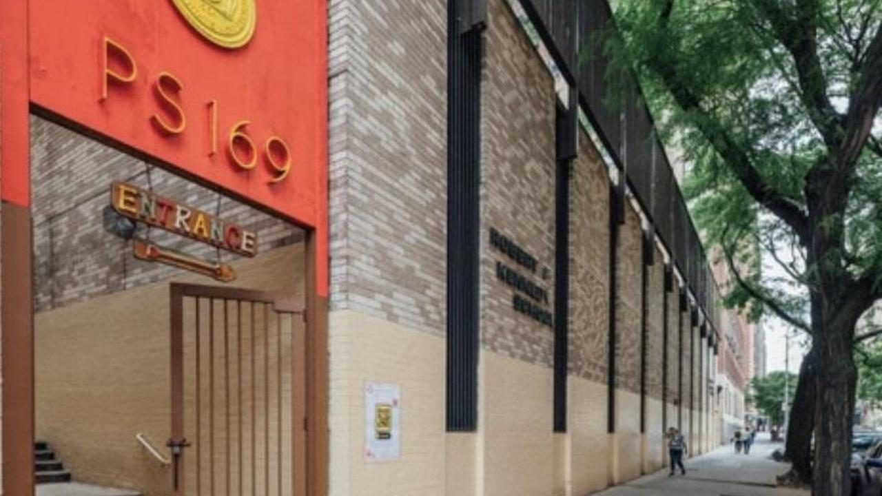 The P169M entrance on East 88th Street: a vermilion canopy with brass numerals over the gate, beside the brick facade